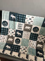 Double Minky baby blanket in navy, dusty blue and gray with a woodland theme incorporating deer, arrows, canoes, antlers and mountains