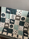 Double Minky baby blanket in navy, dusty blue and gray with a woodland theme incorporating deer, arrows, canoes, antlers and mountains