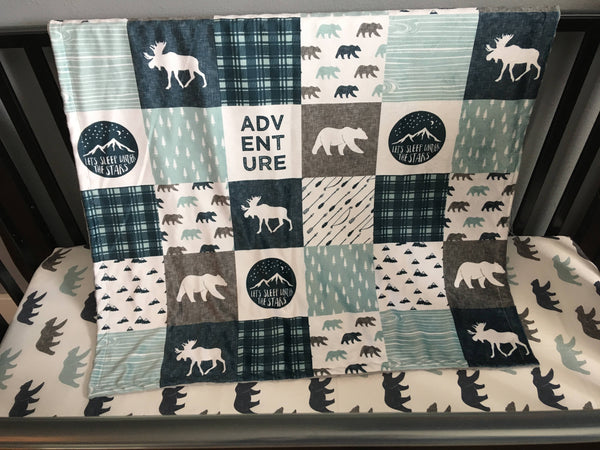 Double Minky baby blanket in navy, dusty blue and gray with a woodland theme incorporating deer, arrows, canoes, antlers and mountains