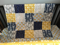 Where the Wild Things Are inspired crib bedding set in navy, gray and a golden yellow with woodland fabrics of arrows, crowns, tans trees