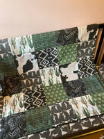 Made to Order Baby Bedding with a western boho theme with cactus, cow, and Aztec prints in dark green, gray and black