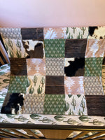 Custom Baby Bedding with a western boho theme with cow hide, cactus, Aztec, succulents, in neutral colors, tan, green, and brown