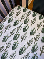 Custom Baby Bedding with a western boho theme with cow hide, cactus, Aztec, succulents, in neutral colors, tan, green, and brown